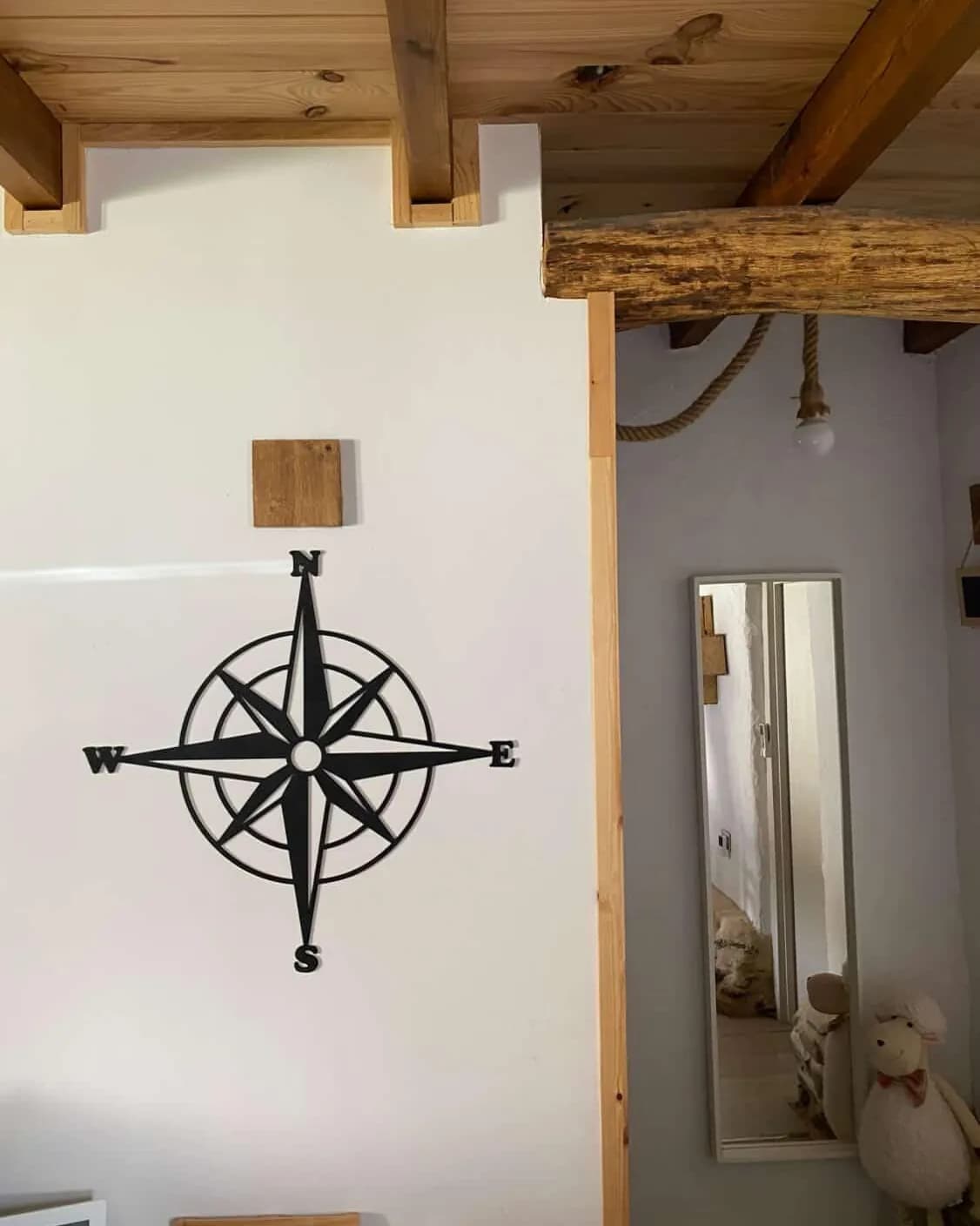 La rosa de los vientos colgada en la pared de una casa con vigas de madera