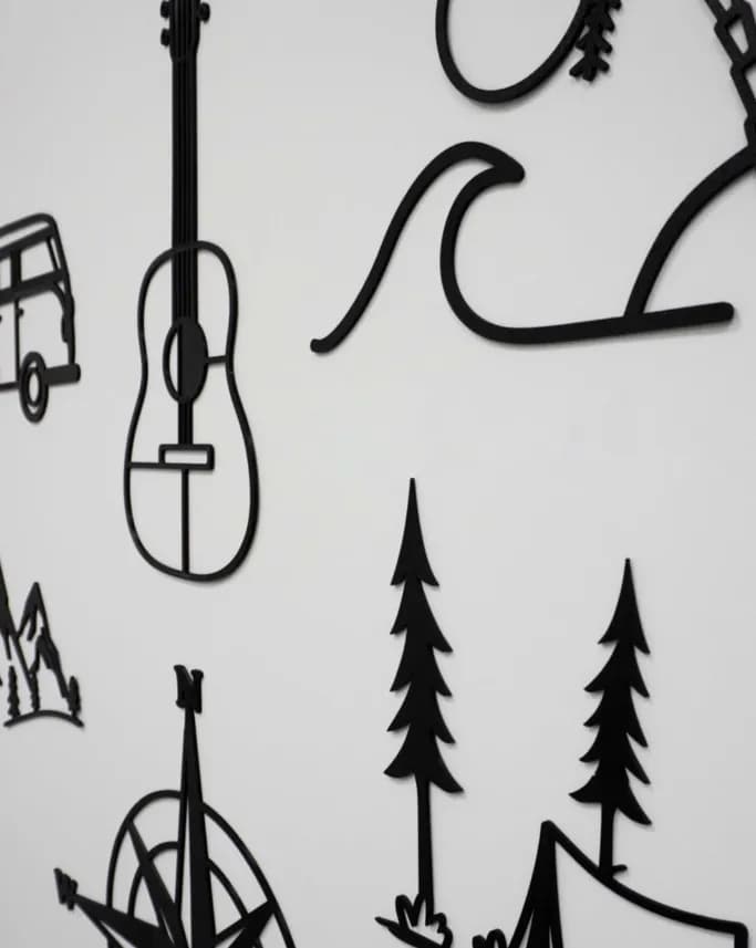 Pared con varias siluetas de Encaja3D: guitarra, furgoneta, ola y montañas